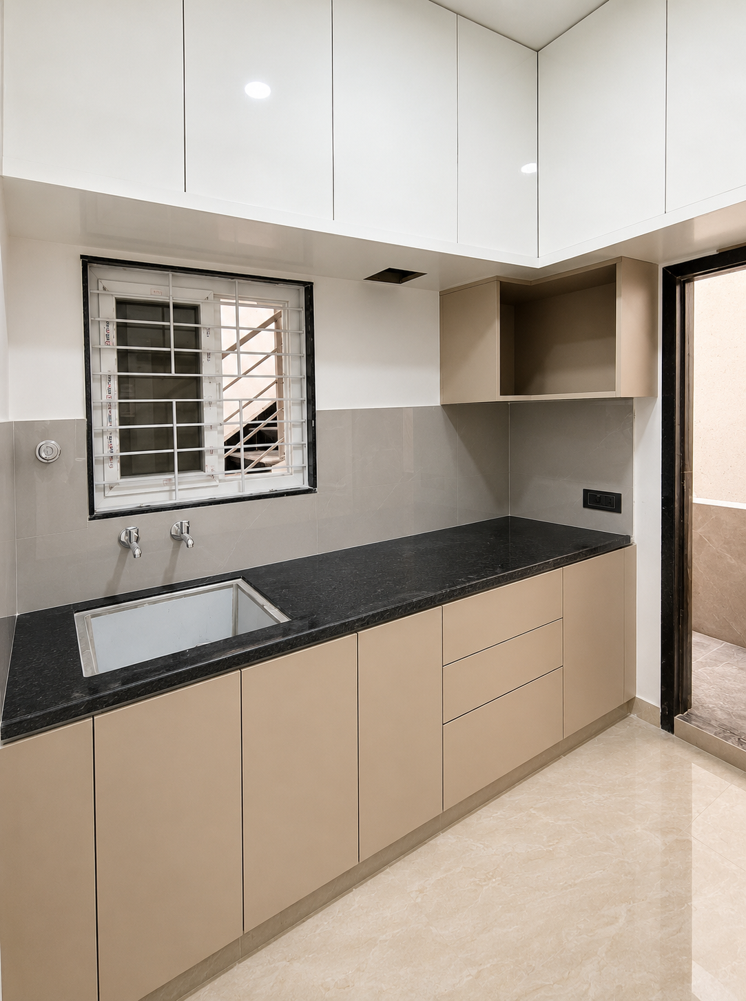 Modern modular kitchen, modular kitchen design, contemporary kitchen, furnished kitchen, spacious kitchen, compact modular kitchen, black granite countertop, granite kitchen platform, L-shaped kitchen, kitchen cabinets, overhead kitchen cabinets, wall-mounted cabinets, lower kitchen cabinets, kitchen drawers, built-in kitchen storage, kitchen storage cabinets, beige kitchen cabinets, glossy kitchen cabinets, modern kitchen interiors, sleek kitchen design, minimalist kitchen, functional kitchen space, spacious kitchen platform, granite countertop kitchen, stainless steel kitchen sink, single bowl kitchen sink, kitchen faucet, kitchen tap, tiled kitchen backsplash, grey kitchen tiles, kitchen ventilation window, grilled kitchen window, natural light kitchen, well-lit kitchen, clean kitchen interior, organized kitchen space, modern home kitchen, apartment kitchen, rental apartment kitchen, premium kitchen interior, practical kitchen design, contemporary home kitchen, ready-to-use kitchen, fully furnished kitchen, kitchen storage solutions, modular storage kitchen, modern cabinet kitchen, elegant kitchen interior, spacious cooking area, functional rental home kitchen.